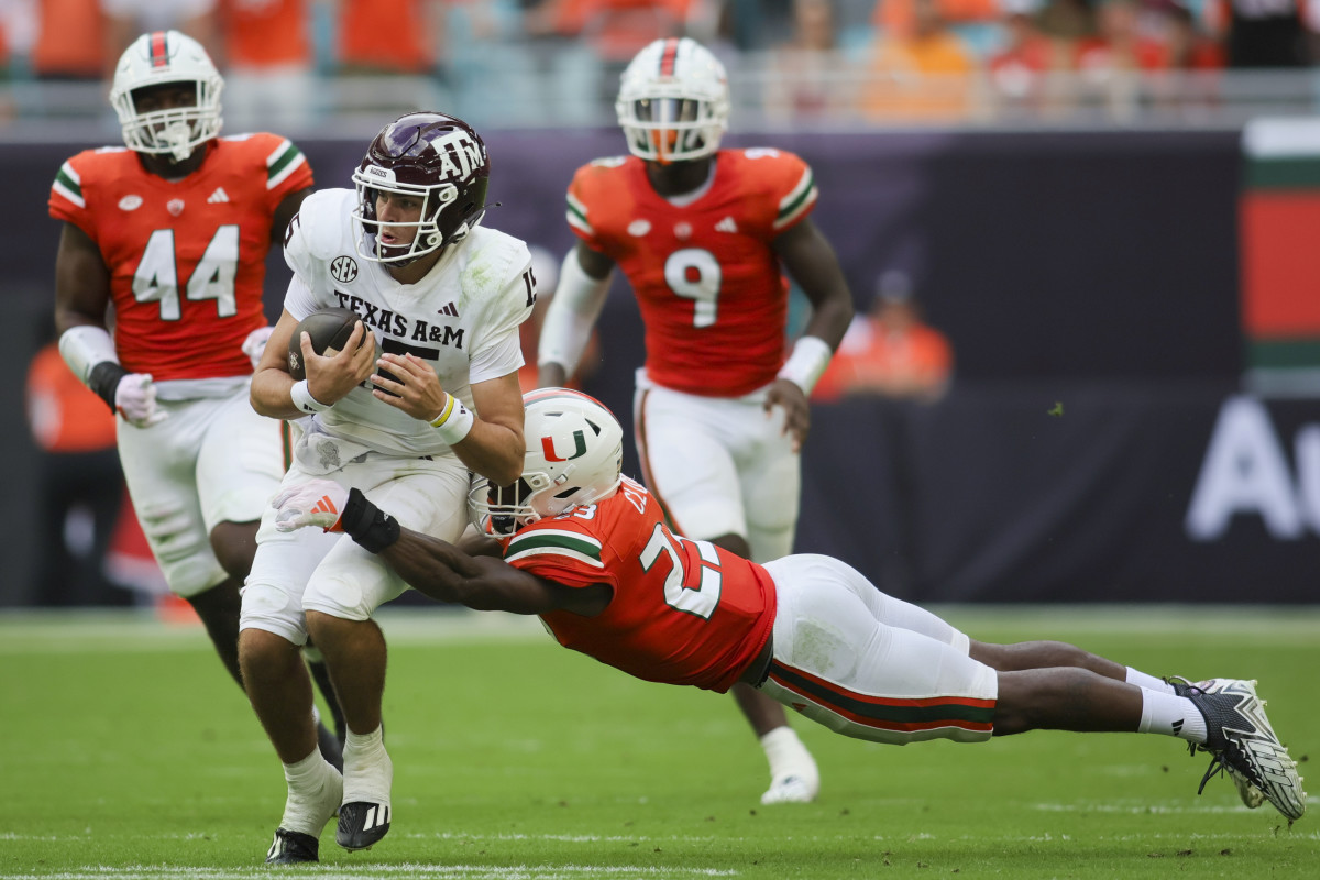 Sep 9, 2023; Miami Gardens, Florida, USA; Texas A&M Aggies quarterback Conner Weigman (15) runs with the football against Miami Hurricanes linebacker K.J. Cloyd (23) during the second quarter at Hard Rock Stadium. Mandatory Credit: Sam Navarro-USA TODAY Sports